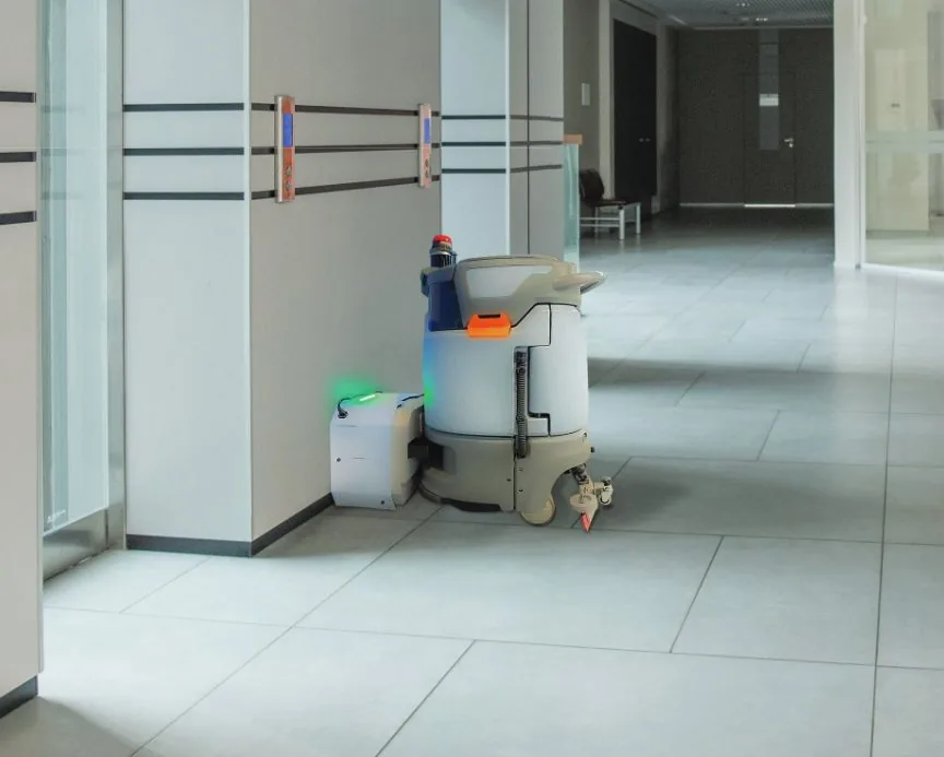 Robot DARE connecté à sa station de recharge dans un couloir